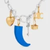 Petit charm en forme de corne en résine, cuir et laiton avec finition dorée Petit charm en forme de corne en résine, cuir et laiton avec finition dorée