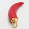 Petit charm en forme de corne en résine, cuir et laiton avec finition dorée