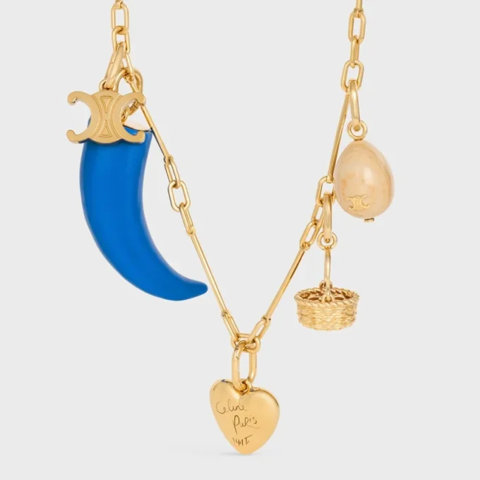 Petit charm en forme de corne en résine, cuir et laiton avec finition dorée Petit charm en forme de corne en résine, cuir et laiton avec finition dorée