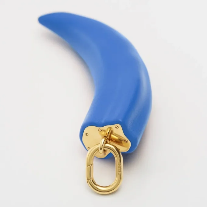 Petit charm en forme de corne en résine, cuir et laiton avec finition dorée Petit charm en forme de corne en résine, cuir et laiton avec finition dorée