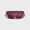 Petit sac Halfmoon Soft Triomphe en cuir d’agneau souple et brillant Petit sac Halfmoon Soft Triomphe en cuir d’agneau souple et brillant