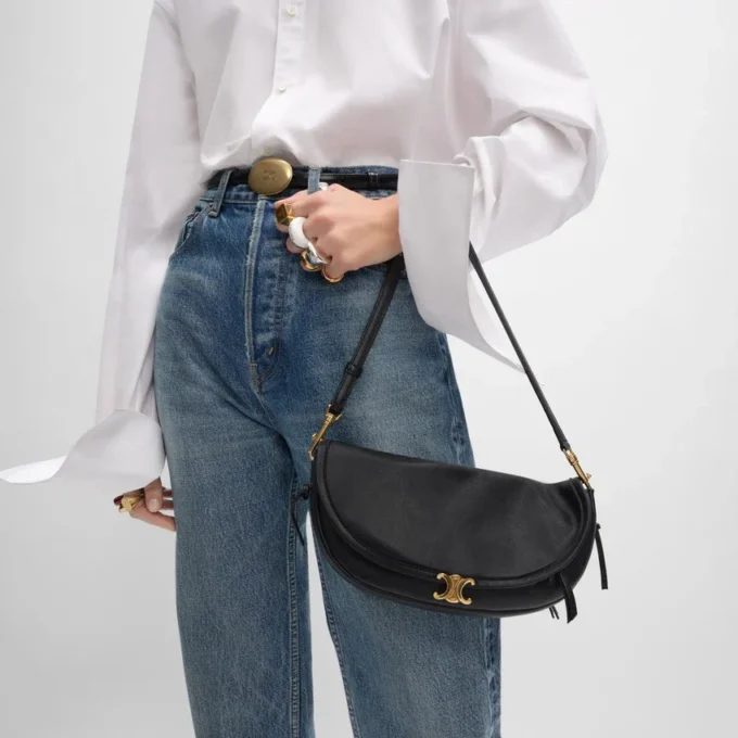 Petit sac Halfmoon Soft Triomphe en cuir d’agneau souple et brillant Petit sac Halfmoon Soft Triomphe en cuir d’agneau souple et brillant