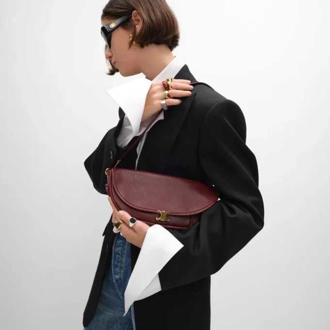 Petit sac Halfmoon Soft Triomphe en cuir d’agneau souple et brillant Petit sac Halfmoon Soft Triomphe en cuir d’agneau souple et brillant