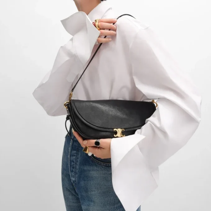 Petit sac Halfmoon Soft Triomphe en cuir d’agneau souple et brillant Petit sac Halfmoon Soft Triomphe en cuir d’agneau souple et brillant