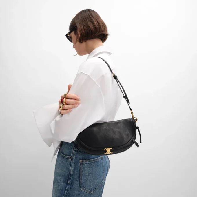 Petit sac Halfmoon Soft Triomphe en cuir d’agneau souple et brillant Petit sac Halfmoon Soft Triomphe en cuir d’agneau souple et brillant